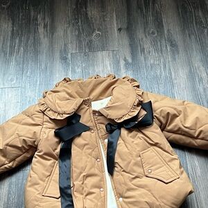 Collared baby coat with black bows